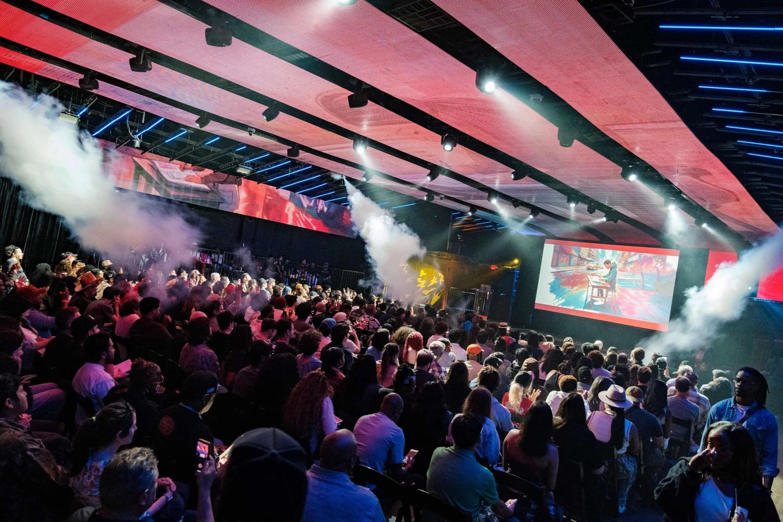 Audience at a live event with stage lighting and video