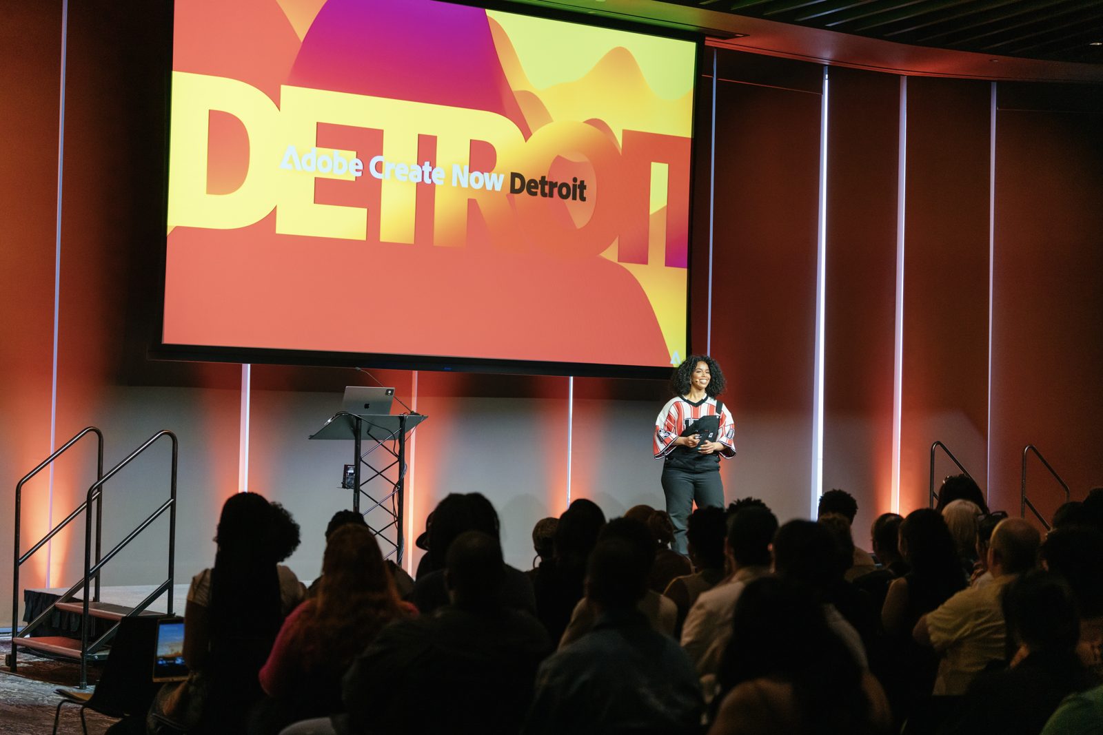 Keynote presenter on stage at a corporate event in Detroit